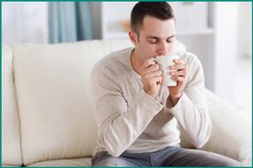 Un homme boit du thé à la menthe pour soigner la dysfonction érectile. 